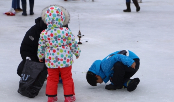 제11회 평창송어축제 참가 가족이 얼음을 깨고 송어낚시를 하고 있다